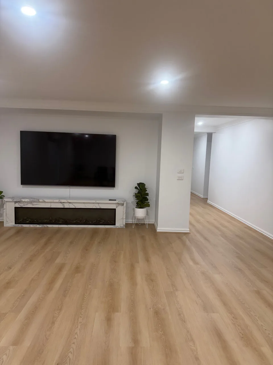 Renewed Epping living space with crisp white walls and warm timber flooring